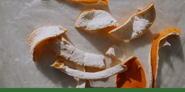 Dried orange peels arranged on a pale surface